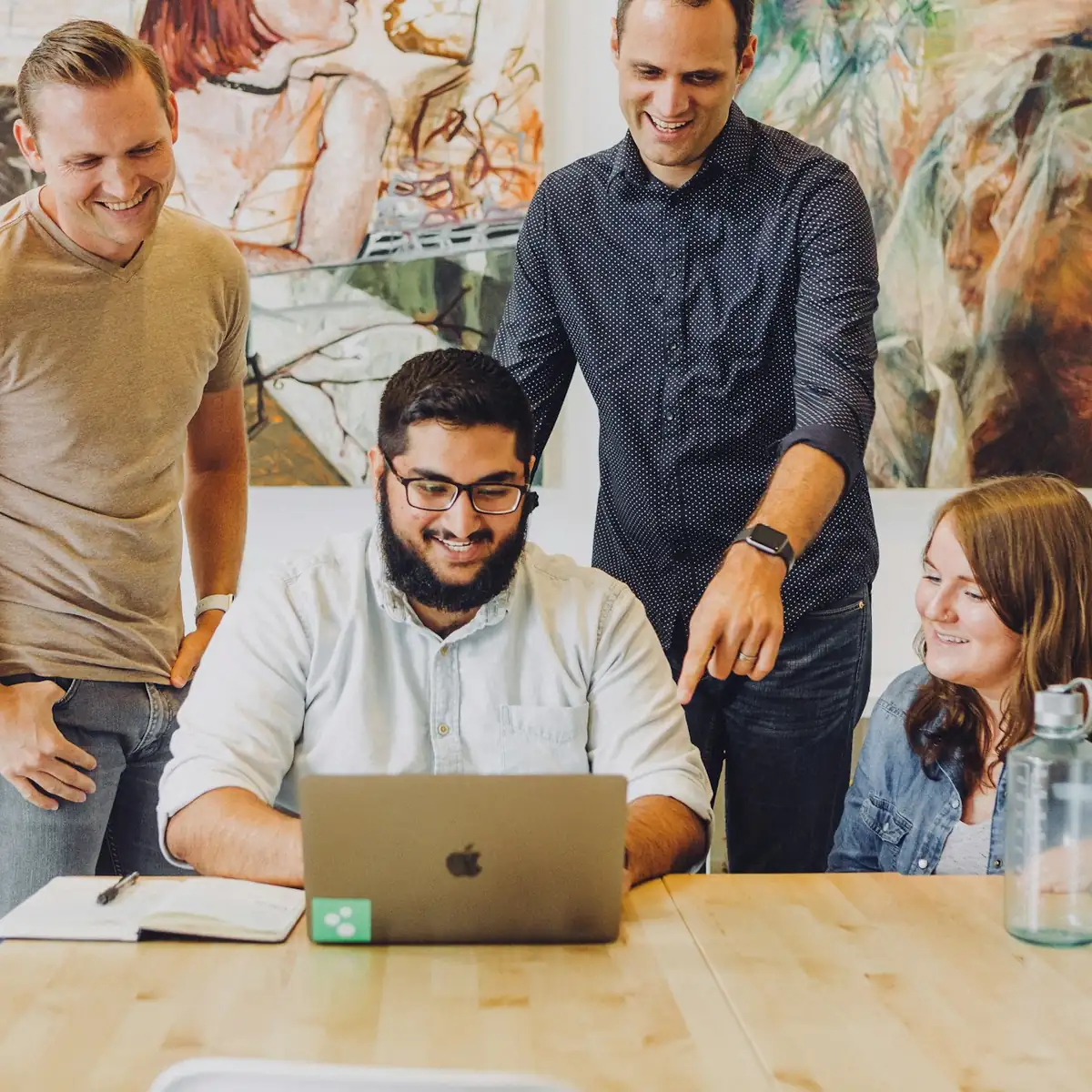 Equipe reunida em volta de um notebook analisando resultados; fotografia ilustrativa