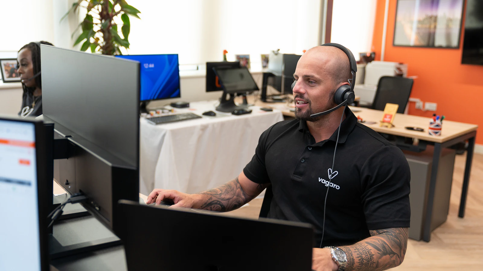 Profissional de atendimento usando headset diante do computador